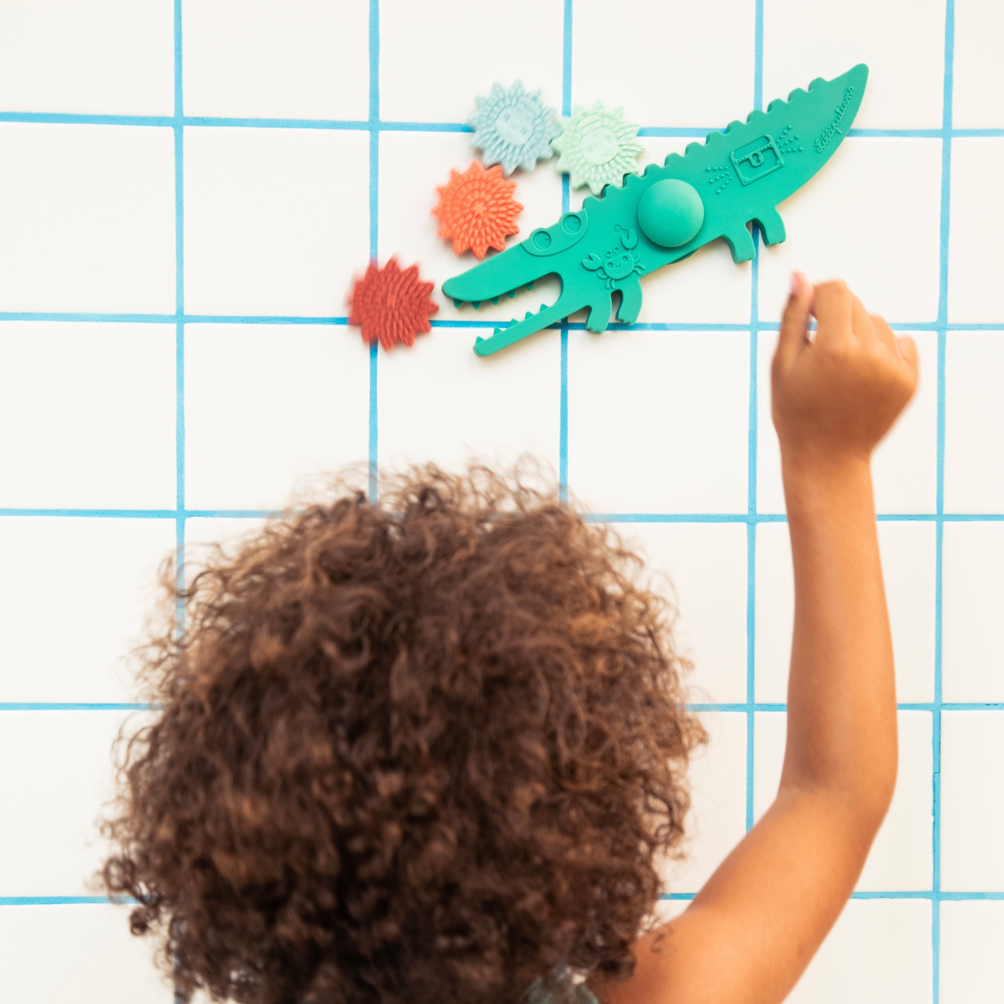 Enfant jouant avec jouet de bain crocodile Lilliputiens